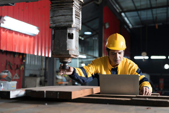 Manufacturing industry and factories. Heavy industry machine. Maintenance or repair industrial machine. Asian male factory engineer inspecting or maintenance vertical drilling machine in factory