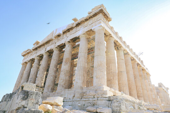 The Parthenon temple on the Acropolis of Athens stands under a clear blue sky, showcasing ancient Greek architecture with Doric columns and ongoing restoration work.