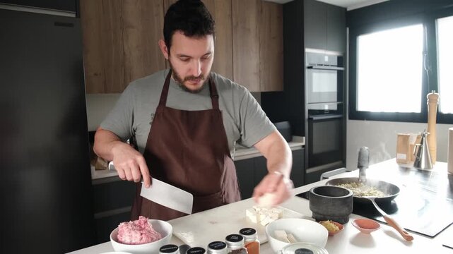 Male chef cutting tofu with a cleaver knife to cook a delicious asian recipe at home