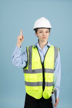 Confident woman worker pointing index finger upwards in building site