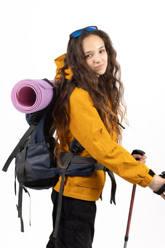 Active woman hiker carrying backpack while walking with trekking sticks