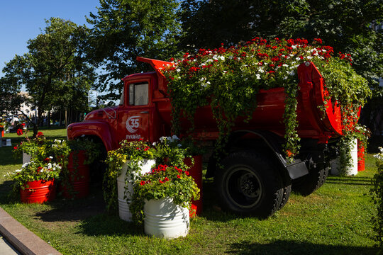 A red vintage truck has been turned into a decorative flower bed with blooming geraniums in a city park. Russia, Moscow 19.07.2026