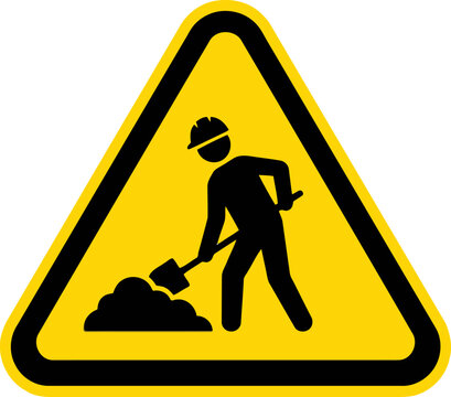 Construction worker digging, warning sign