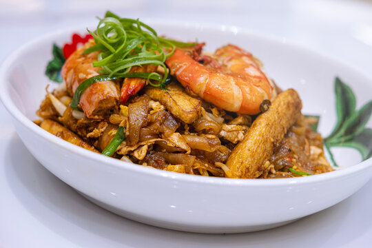Serving of famous Penang Char Kway Teow, a popular fried flat noodle with condiments in Malaysia.