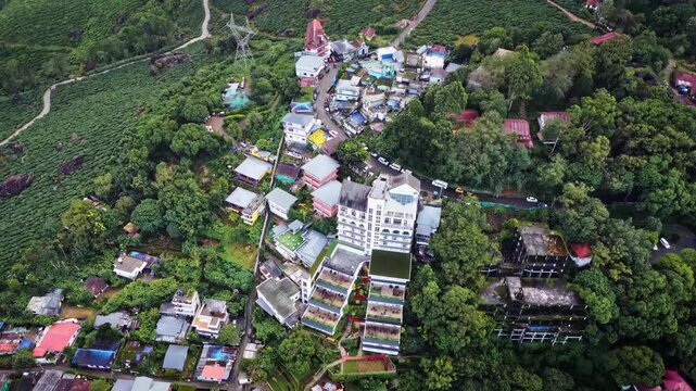 Aerial drone view of Munnar town and hillside resorts surrounded by lush tea plantations and tropical greenery in Kerala, India, showcasing the hill station and tourism landscape of the Western ghats