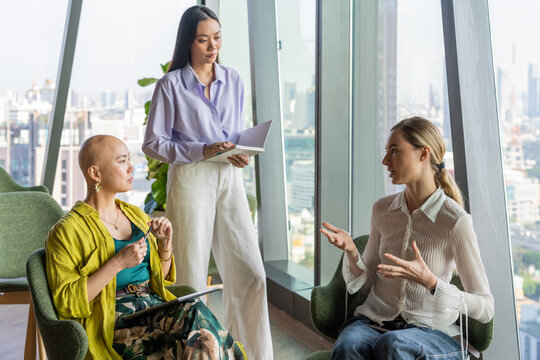 Women Discuss Ideas in a Modern Office With City View