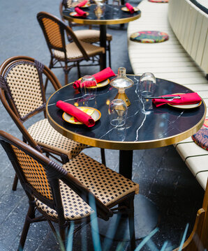 Elegant Outdoor Restaurant Table Setting with Red Napkins and Bistro Chairs