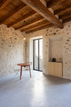 The interior of a refurbished room in an old house with stone walls. Inside, there is a table and a sink for washing your hands and making coffee. A warm and cosy space.