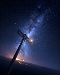 Naklejka premium A conceptual street sign pointing towards the spectacular Milky Way galaxy in a starry night sky, symbolizing discovery, dreams, and space exploration.