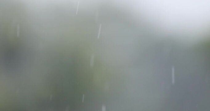Rain falling over a soft blurred gray background. Atmospheric motion background ideal for weather scenes, cinematic overlays, video editing, nature projects, and visual effects