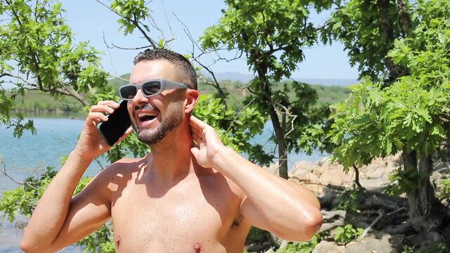 Man calling with his cellphone during the summer time at the beach