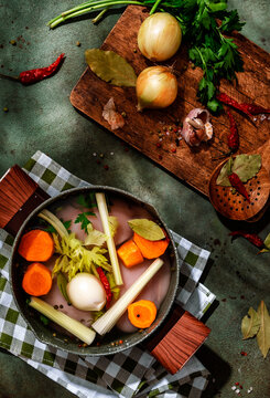 Raw chicken and fresh root vegetables in a pot ready for cooking
