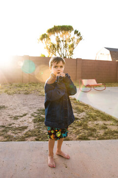 Boy standing in yard in jean jacket