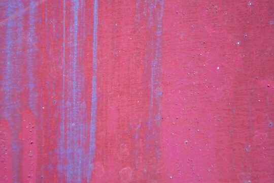 Close-up view of distressed pink surface featuring vertical color streaks and subtle stain effects. Modern artistic grunge texture background for banner cover and creative project.