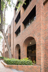 Fototapeta premium Buildings with brick facade and arches with garden