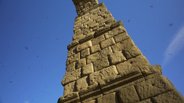 Low angle architectural view of the Roman Aqueduct of Segovia against a clear blue sky