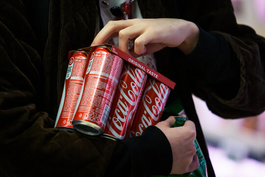 RIGA, LATVIA. 12th March 2026. Close-up of a person holding a cardboard pack of Coca-Cola Original Taste aluminum soda cans.