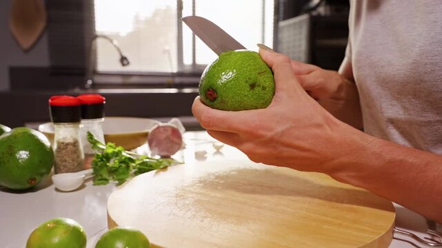 Woman Cuts Ripe Green Avocado with Kitchen Knife over Wooden Board, Healthy Food Preparation and Fresh Cooking