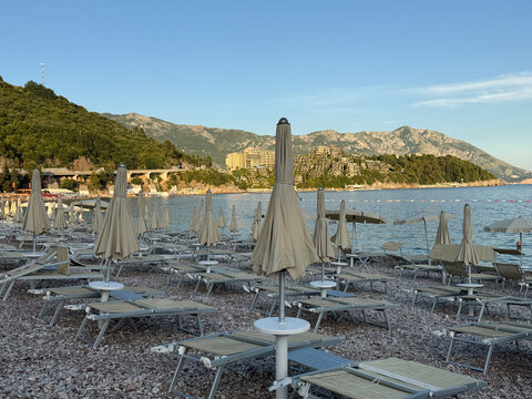 Empty sun loungers on Adriatic Sea beach with peaceful summer atmosphere and clear blue water, coastal vacation concept