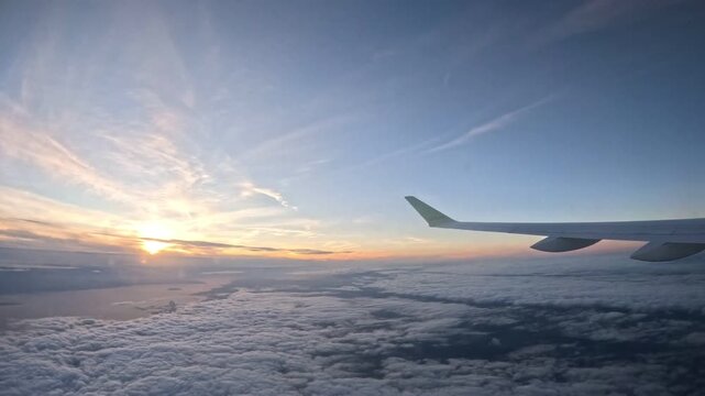 COPENHAGEN, DENMARK - JULY 4, 2024: airBaltic airplane flying high above clouds facing golden sunset