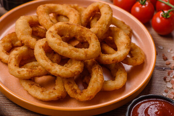 Naklejka premium Deep fried breaded onion or squid rings, crispy fast food snacks. Fried onion or squid rings