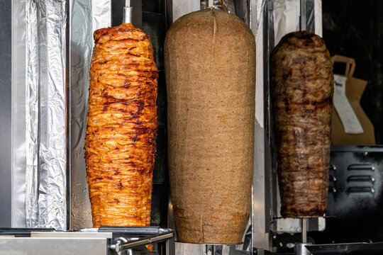 vertical rotisserie spits loaded with layers of seasoned meat for d&ouml;ner kebab