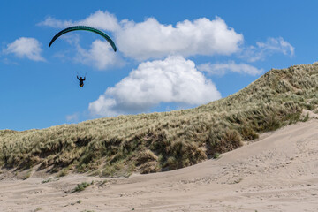 paraglider soaring near coastal sand dunes in the Netherlands © Björn Wylezich