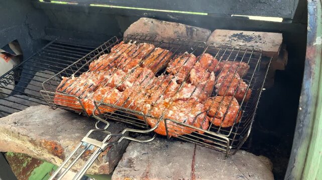 Shashlik grilling in a wire rack on a home barbecue grill, outdoor cooking, summer picnic, delicious homemade food, family gathering.