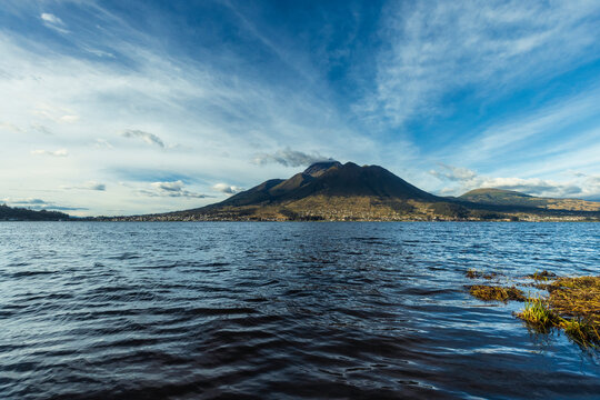 Beautiful San Pablo Lake in Otavalo, Ecuador with the majestic Imbabura Volcano in the background under a blue sky. Rural landscape of the Ecuadorian Andes