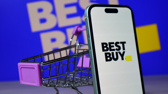 Best Buy retail store logo on smartphone display with miniature shopping cart.