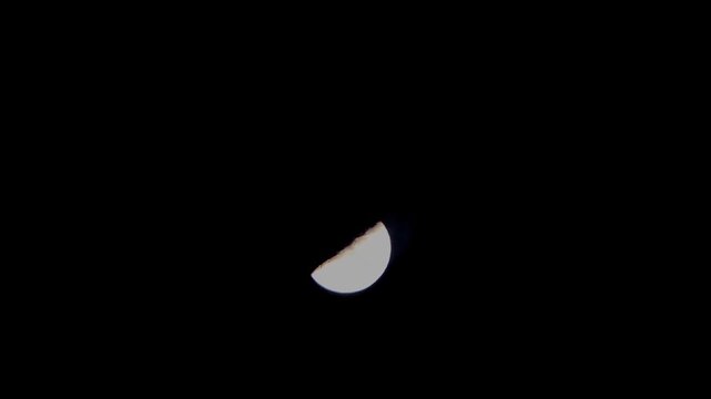 time lapse view of the half moon in the dark night sky