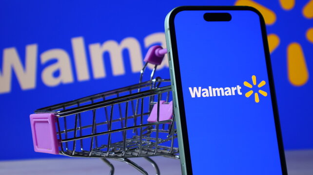 Walmart mobile application on smartphone with grocery shopping cart on table.