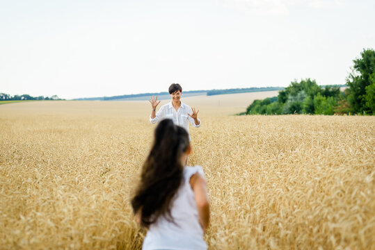 World food crisis. Deficit of grain in the world markets. Mom and daughter are walking in a wheat field.