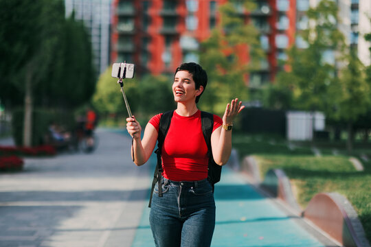 Woman vlogging and streaming live in city park