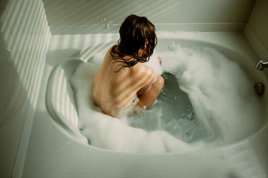 Woman sitting in bathtub