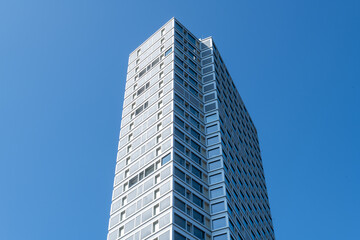 Obraz premium Modern skyscraper viewed from below against clear blue sky