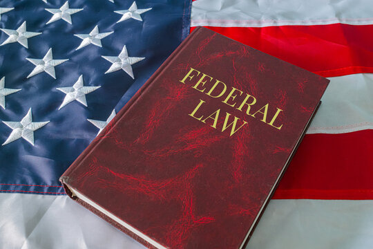 Federal Law book on USA flag background, American legal system and government regulation concept