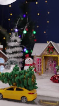 A yellow car drives into the center of the Christmas village