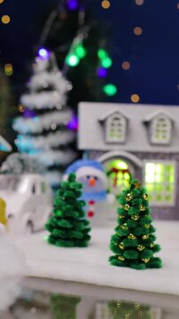 A yellow car and a unique Santa Claus appear in the center of the Christmas village