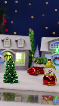 A yellow car and a unique Santa Claus appear in the center of the Christmas town