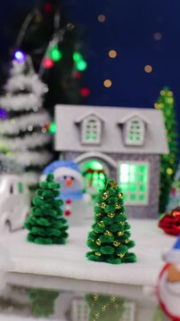 A yellow car drives through the center of the Christmas town