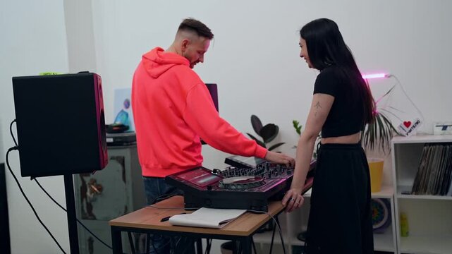 DJs collaborating in large white studio mixing music on DJ controllers and turntables. DJ, collaboration, studio, music, controllers, turntables