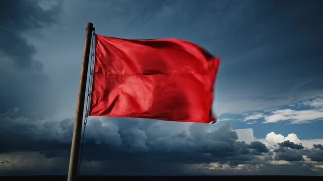 Red Warning Flag Blowing in the Wind Against a Dramatic Stormy Sky Concept of Danger and Risk