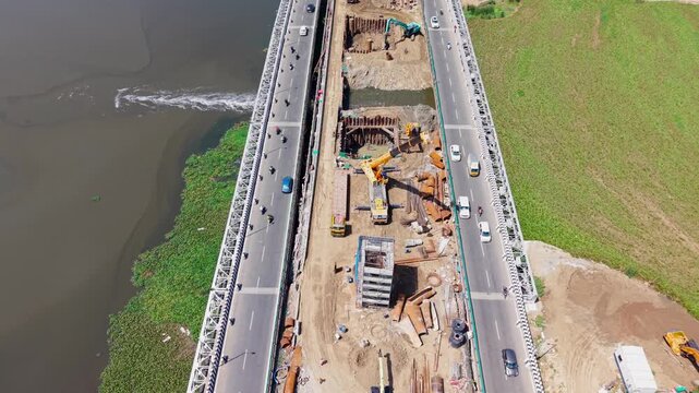 Elevated bridge and expressway construction crossing a green coastal backwater channel