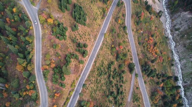 Video of a flight over a winding mountain road. Drone footage flying over a mountain switchback road.