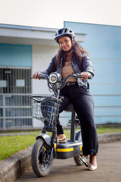 Young Black Brazilian woman on an electric bicycle, representing modern urban mobility, daily commuting, and sustainable transportation for everyday life.