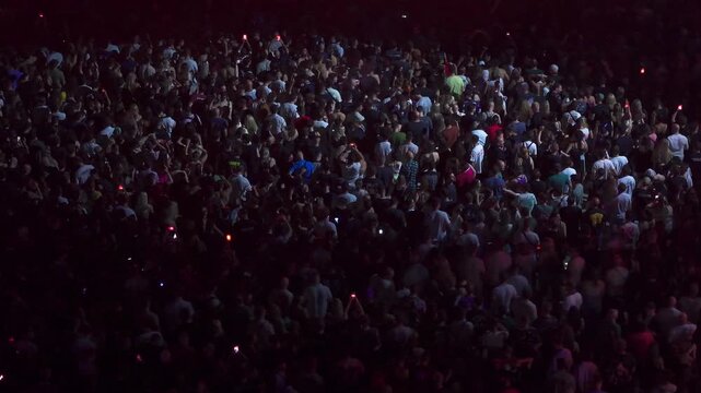 High angle aerial view of massive crowd dancing at live music festival concert