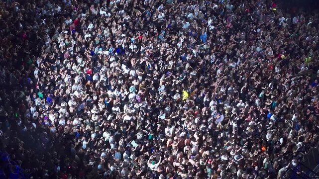 High angle aerial view of massive crowd dancing at live music festival concert