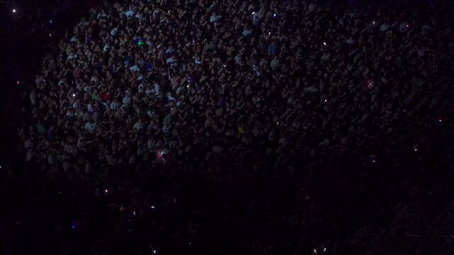 High angle aerial view of massive crowd dancing at live music festival concert