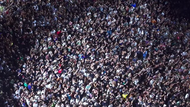 High angle aerial view of massive crowd dancing at live music festival concert